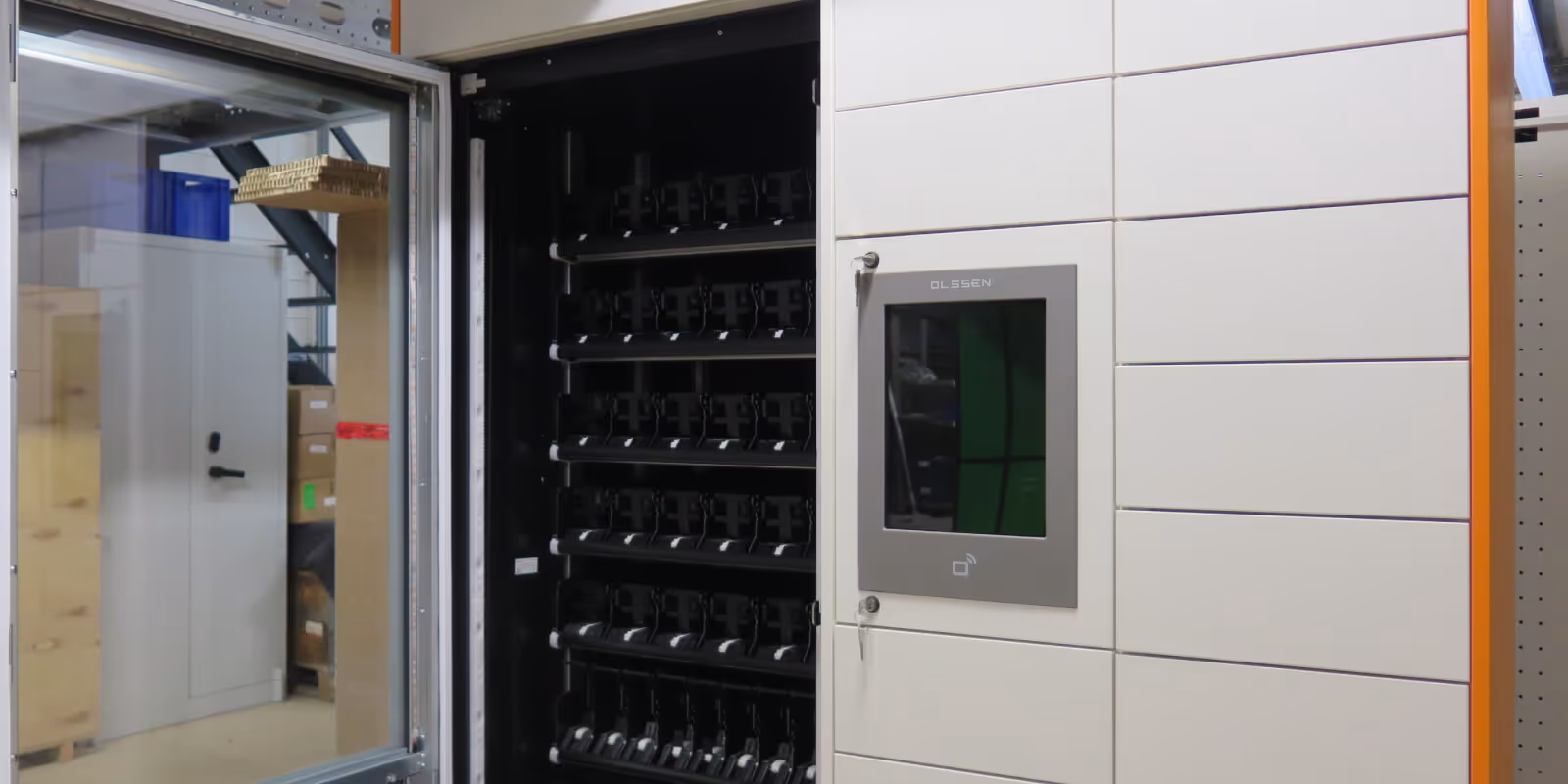 Open automated locker system with multiple empty compartments and a touchscreen panel on the front.