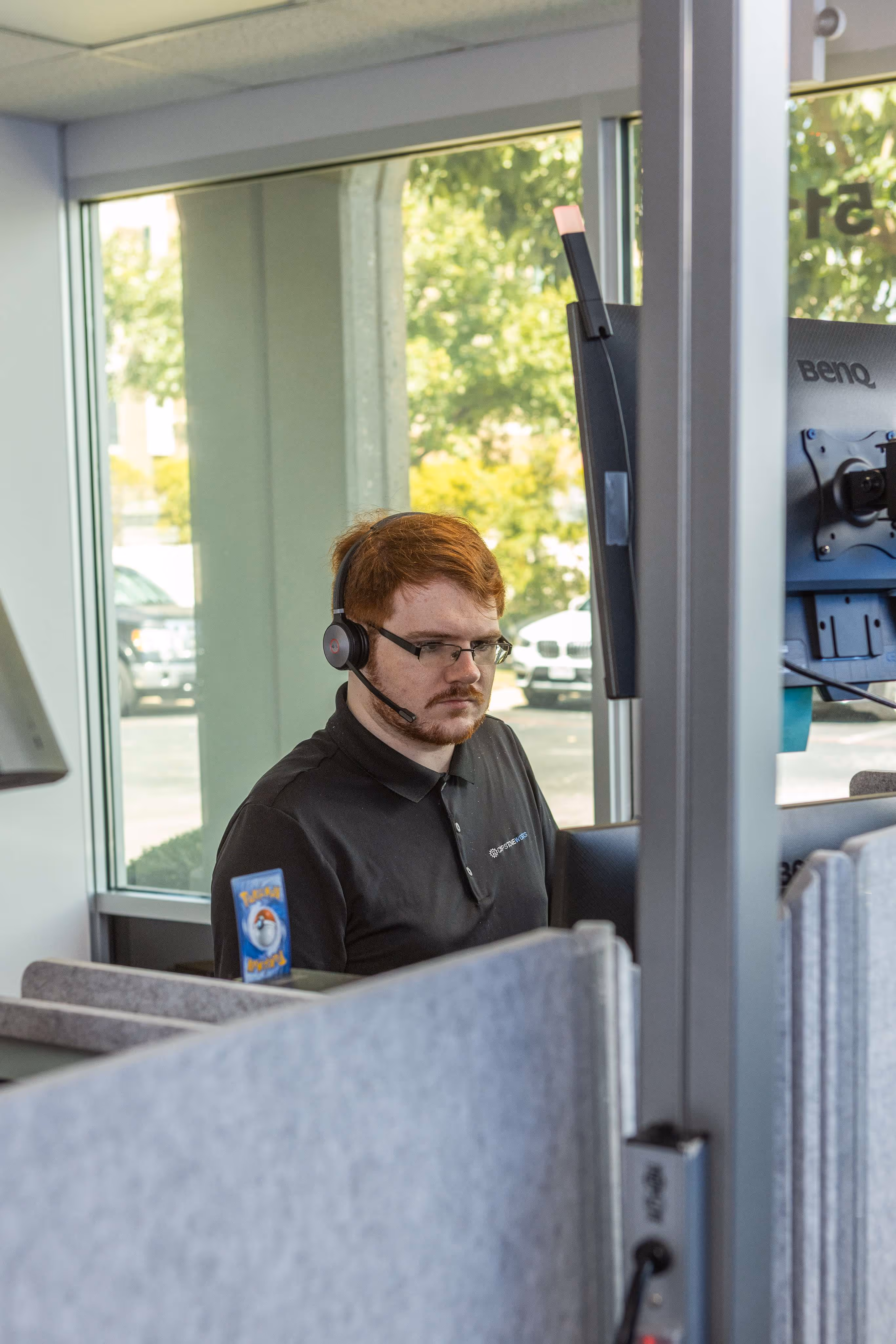 Capstone Works IT support technician wearing headset working at dual-monitor desk in Austin office