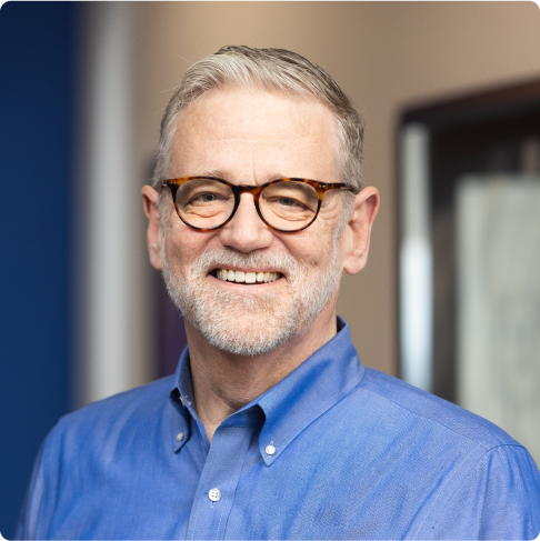 Smiling IT professional in glasses and blue shirt representing Capstone Works managed IT services Austin TX