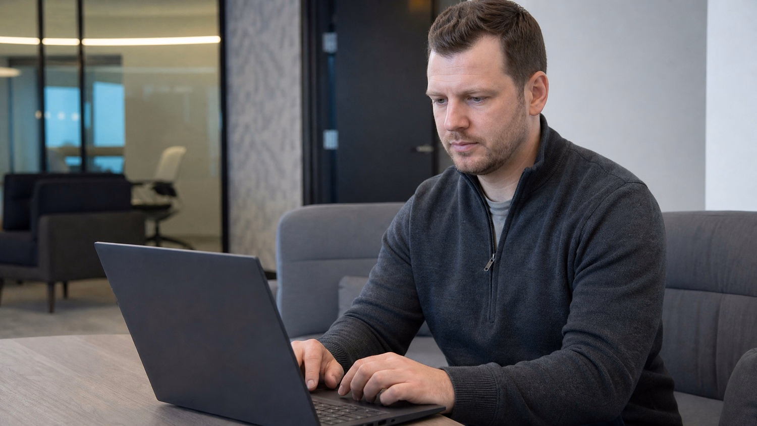 LOUNGE AREA LAPTOP, one person working on a laptop in a casual office loung