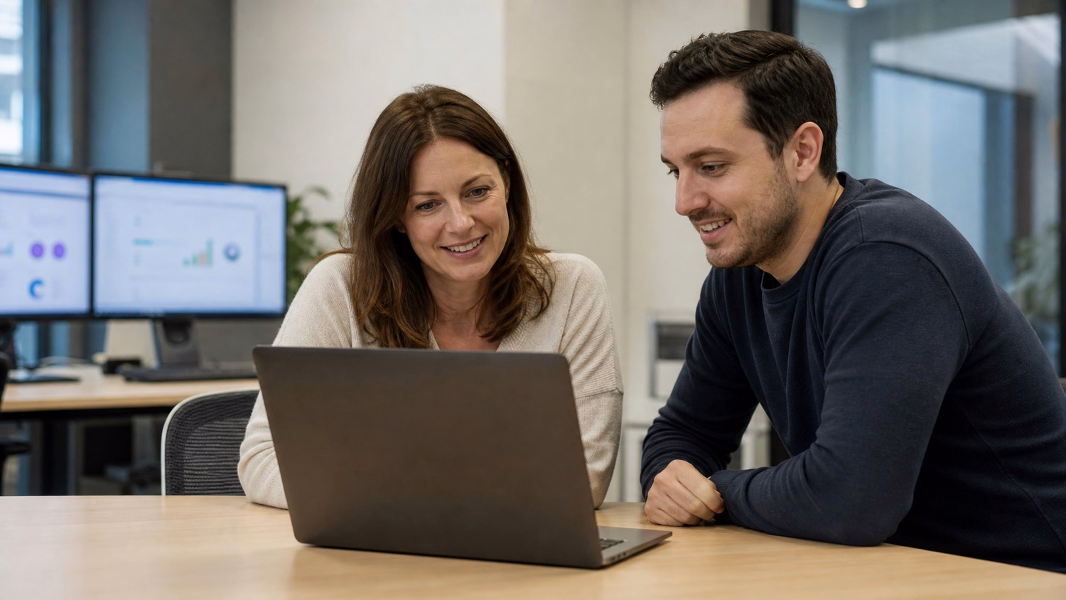 Couple reviewing cloud dashboard on laptop screen
