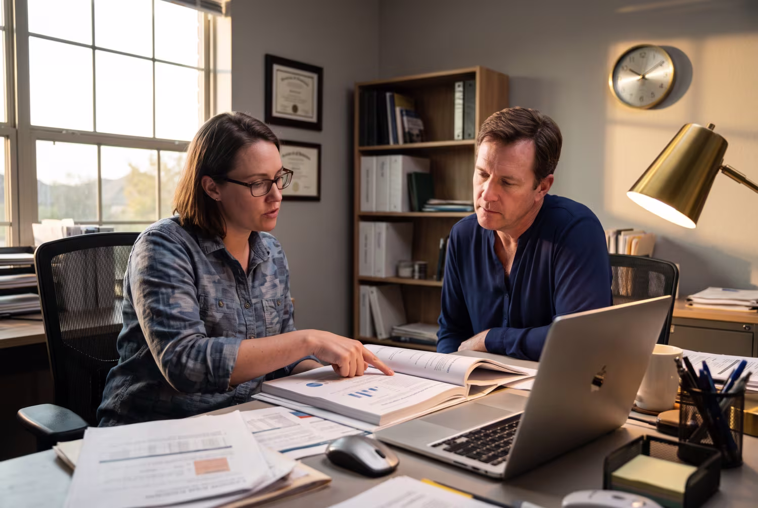 IT consultant discussing report with business manager in office