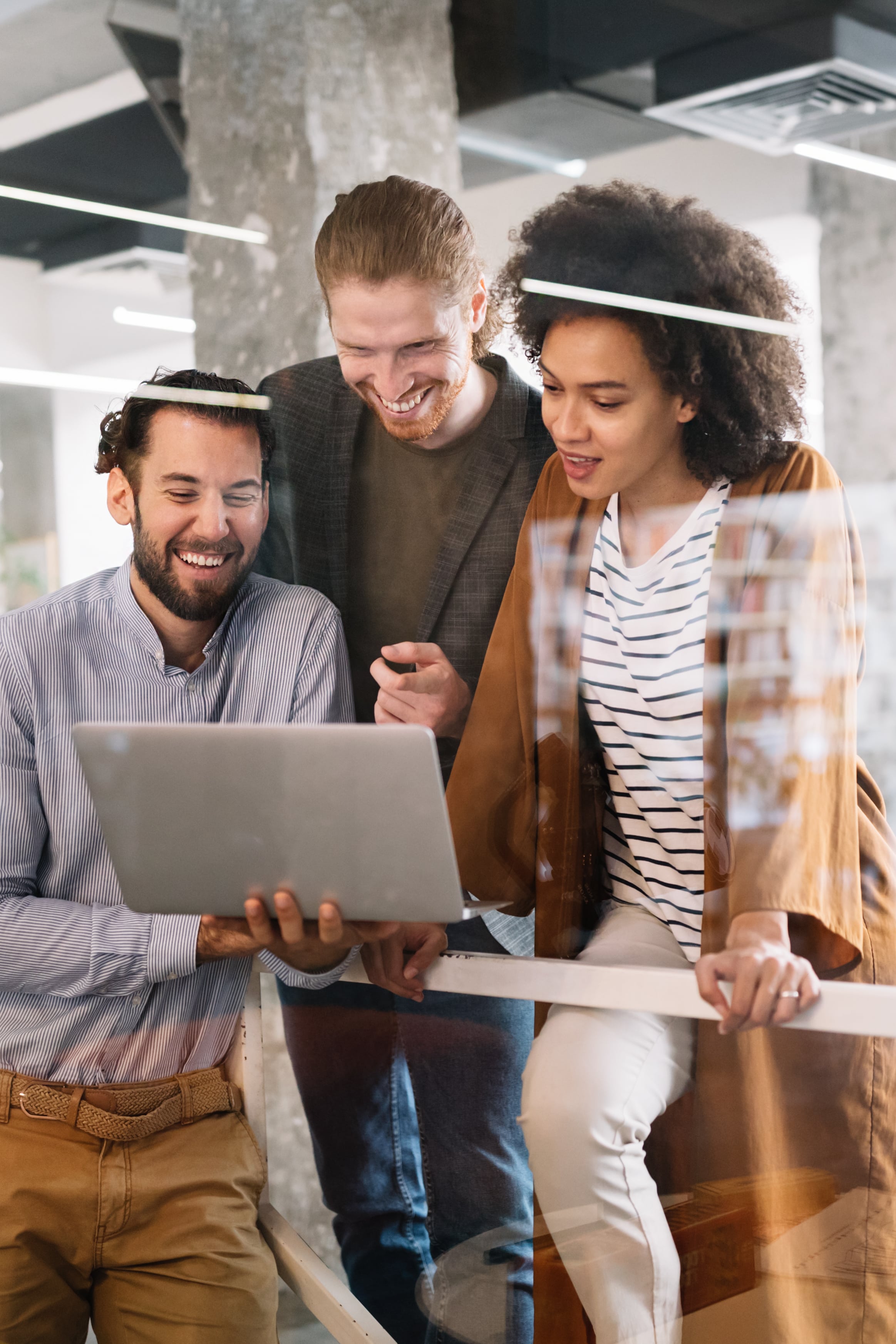 A group of business people happily looking at a computer