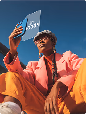 Young woman in colorful outfit taking a selfie with a floating phone screen showing 'More foods' text against blue sky.