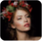 Blurred portrait of a woman with a floral crown and red lipstick.