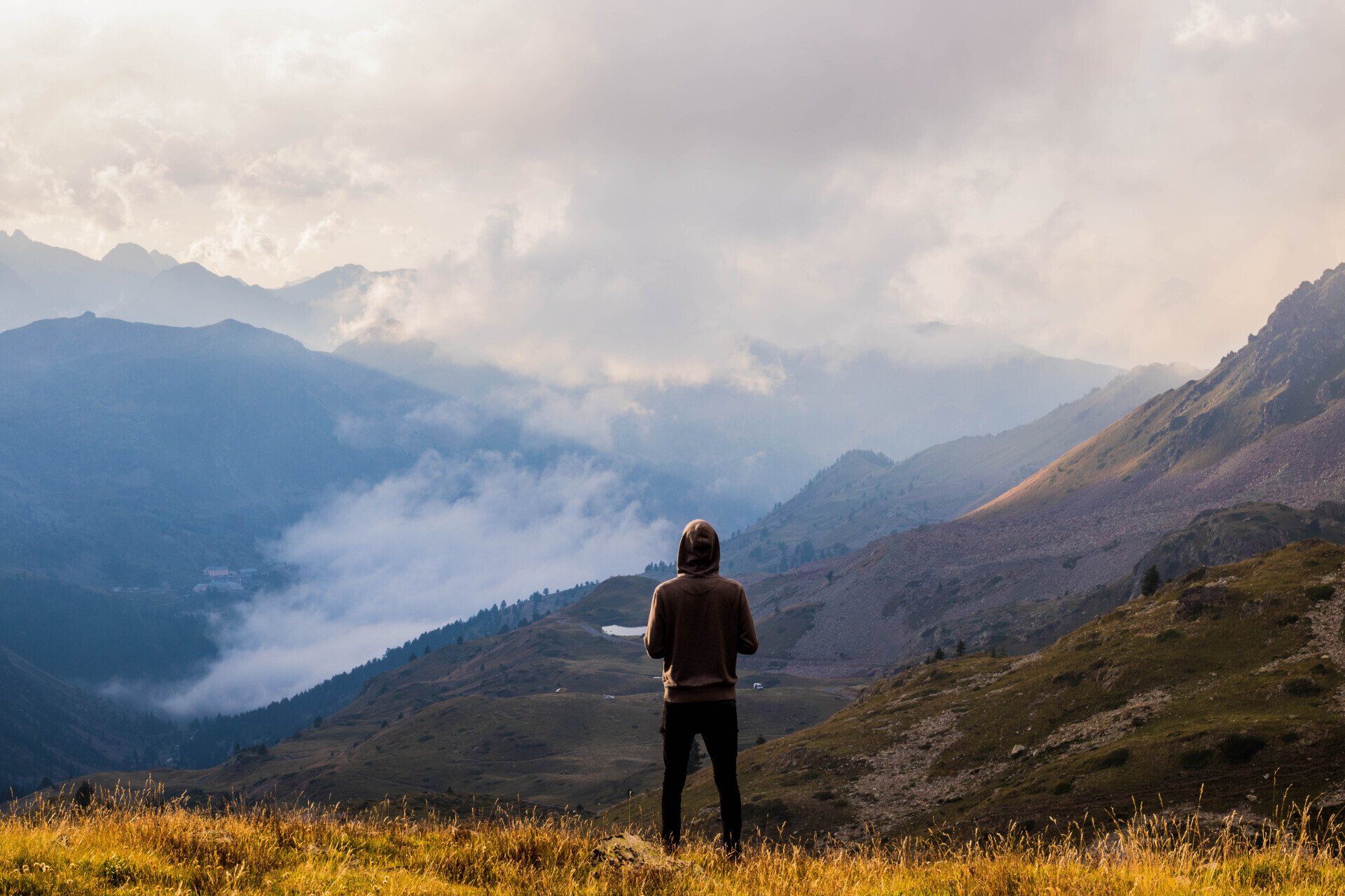 Person overlooking mountain landscape symbolizing leadership journey and navigating business growth challenges.