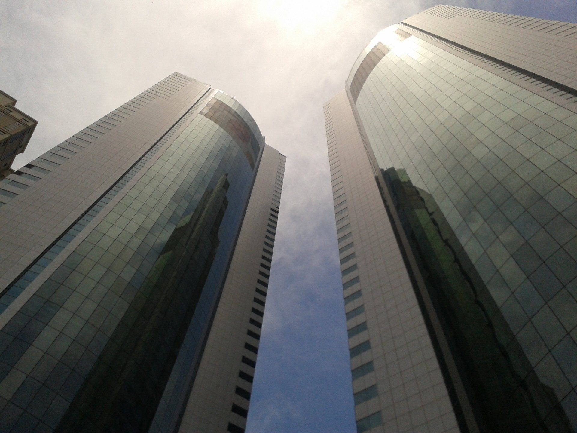 Two glass corporate towers reflecting the cityscape, symbolizing business leadership and executive vision.