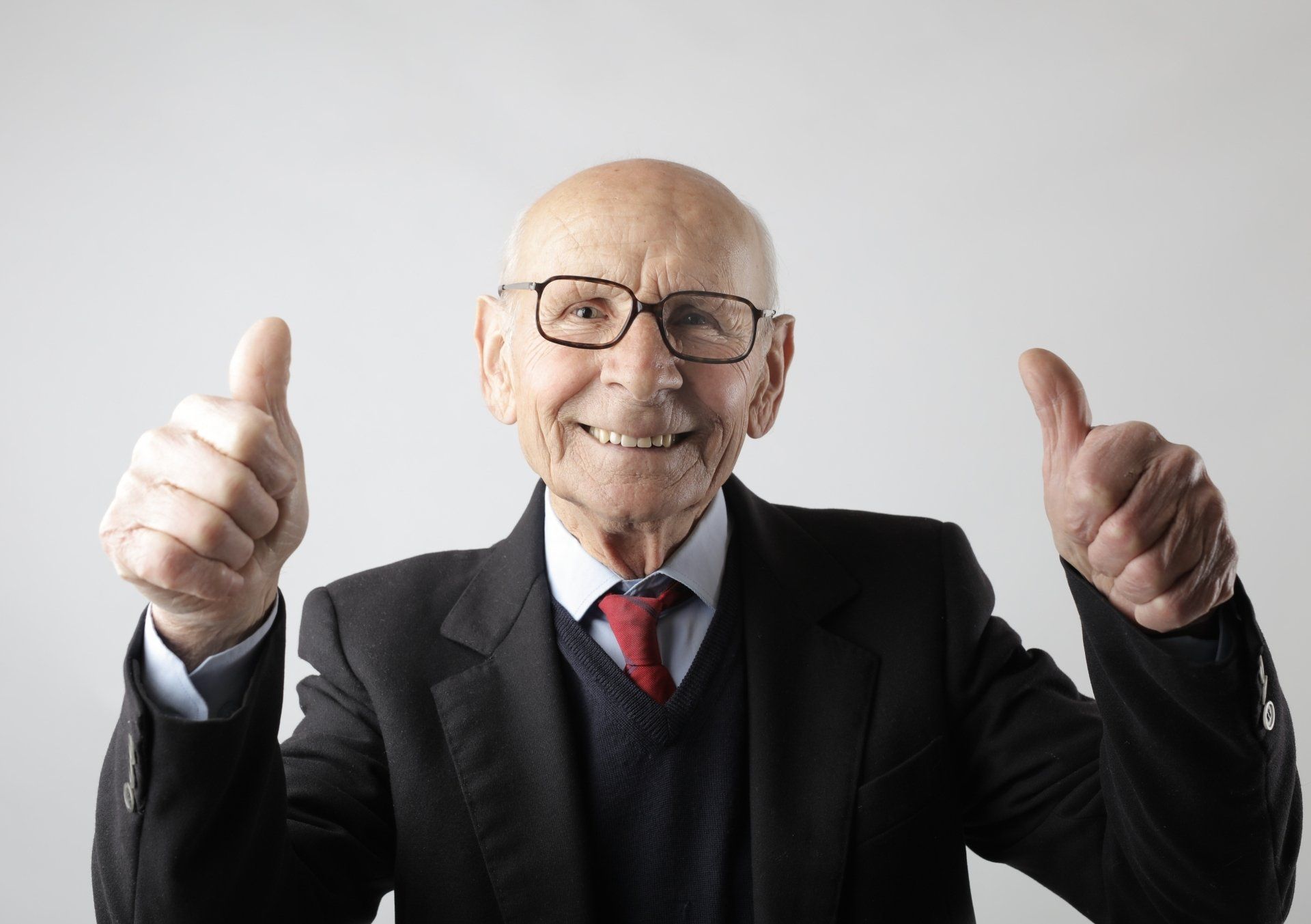 An experienced business leader giving a thumbs-up in a suit.