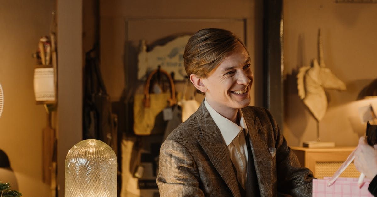 Smiling salesman handing a shopping bag to a satisfied customer in a retail store.
