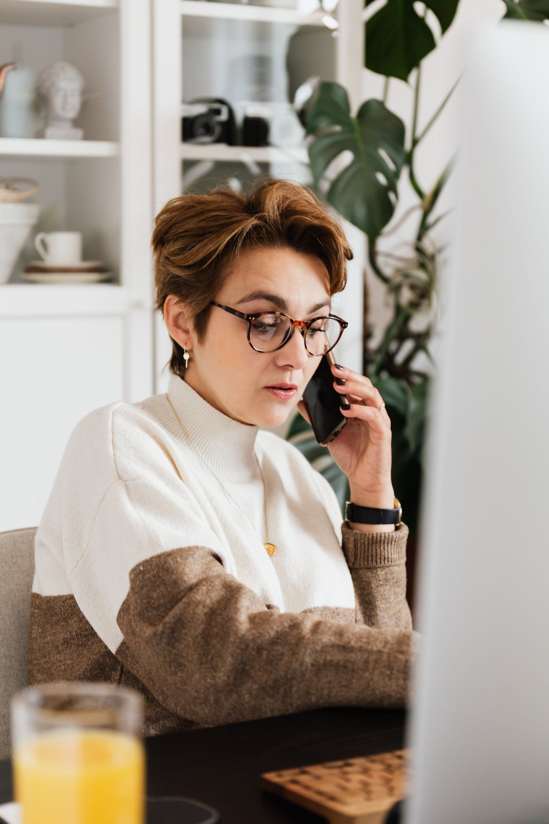 Professional businesswoman on a phone call while working on a computer.