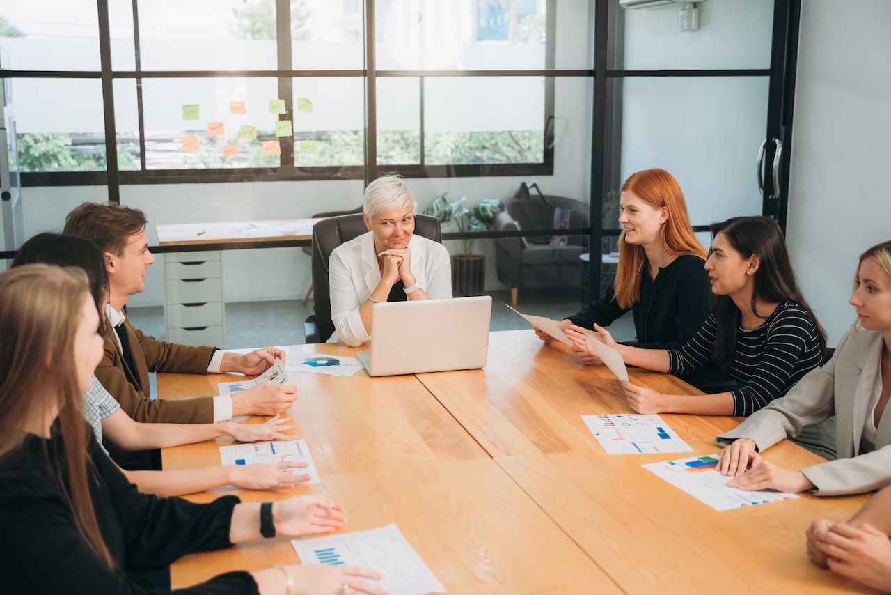 Executive team collaborating in a boardroom, analyzing sales reports and discussing fractional leadership strategies.