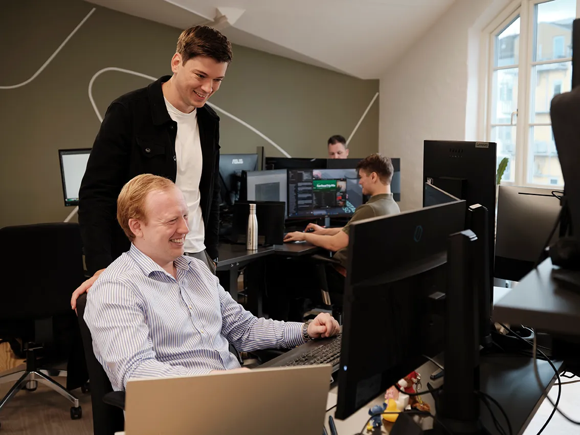 Kollegaer arbejder sammen ved computere på Reportabilitys kontor.