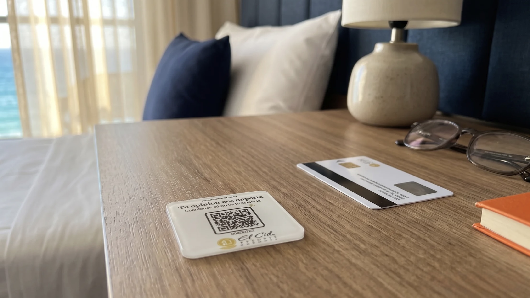 Placa pequeña de MaxReviewer en el buró de una habitación de hotel