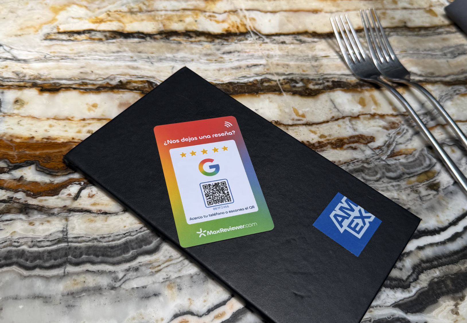 Tarjeta NFC y QR de MaxReviewer junto a la cuenta en un restaurante