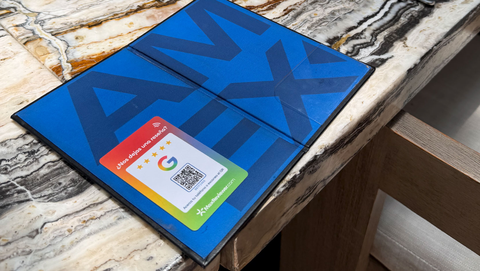 Placa NFC con QR de MaxReviewer junto a la cuenta en un restaurante