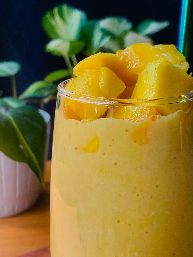 A glass of orange juice with a yellow and orange color.