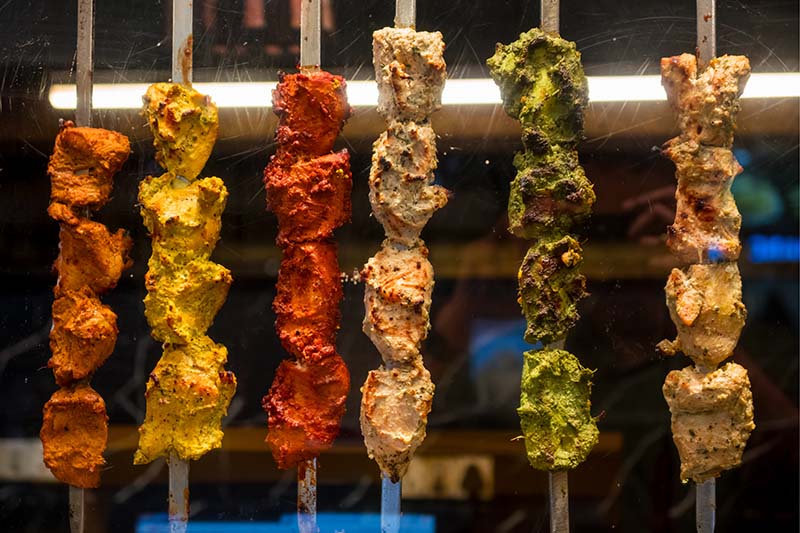 A display of various colored kebabs.