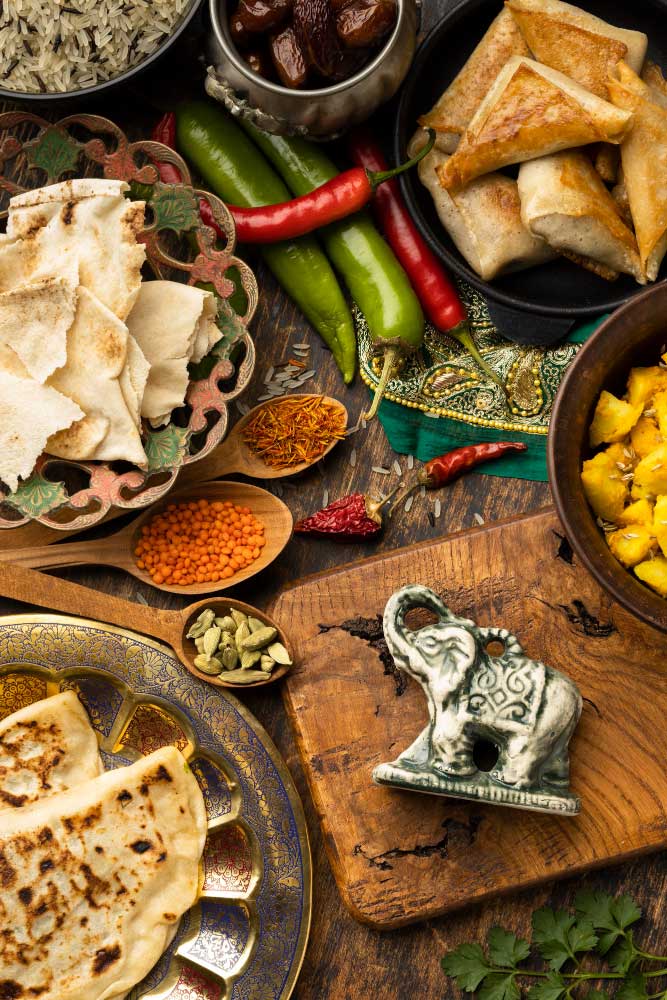 A table full of food including a bowl of peppers and a plate of tortillas.