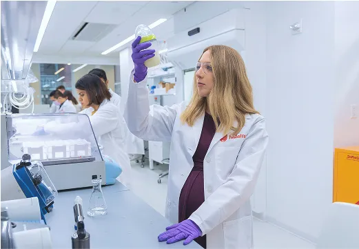 Laura Katz in a white lab coat and safety glasses.