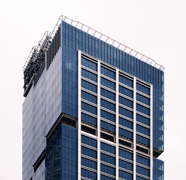 A tall blue building with a sky background