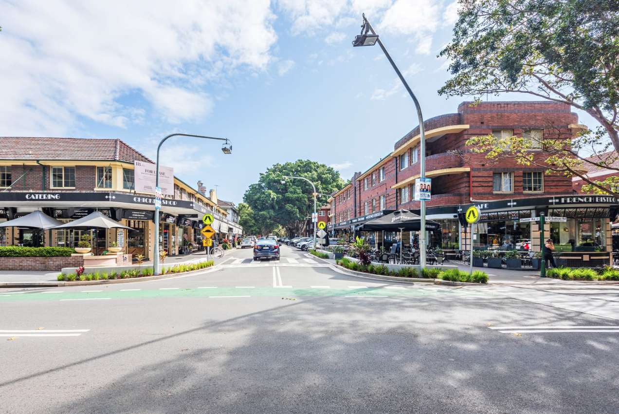 A street with buildings and cars on itAI-generated content may be incorrect.