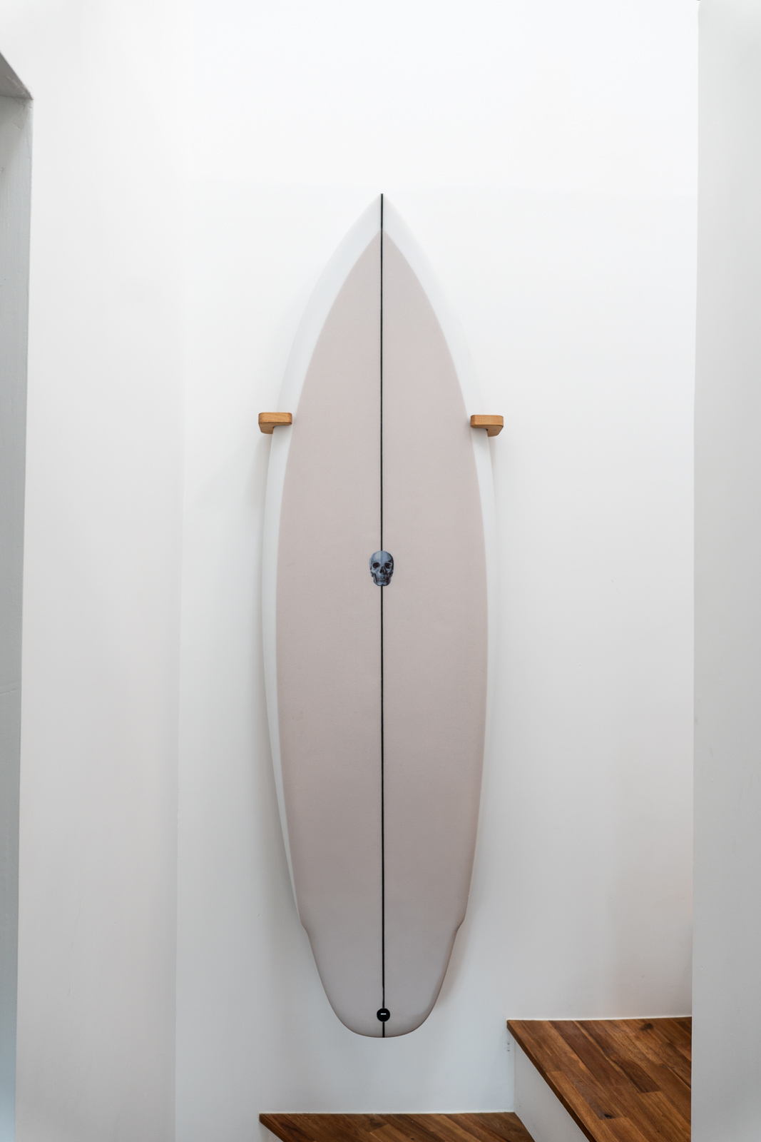 Vertical surfboard wall mount on a white wall