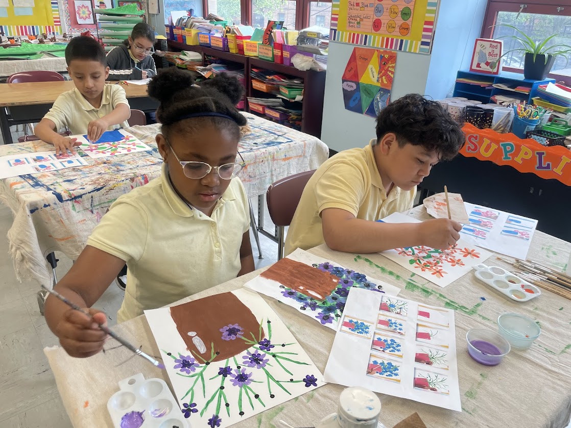 Students painting colorful flower artwork during elementary school art class