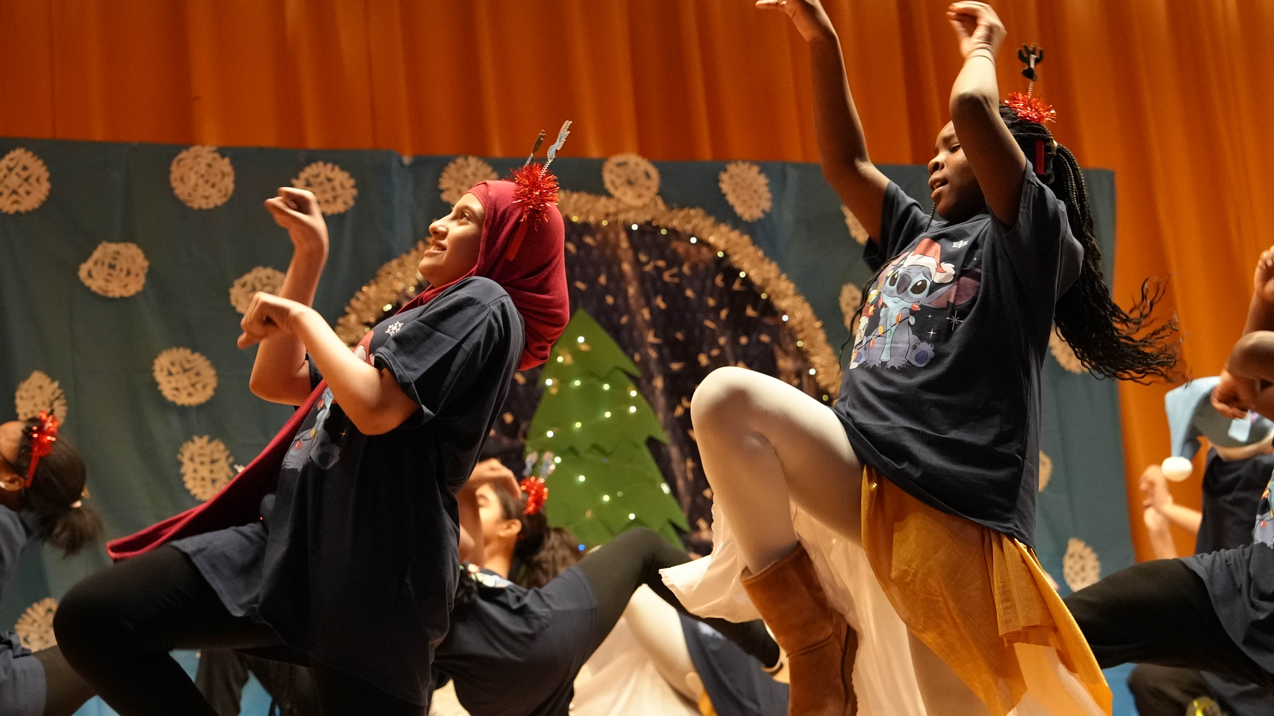 Students performing a holiday dance on stage during school show