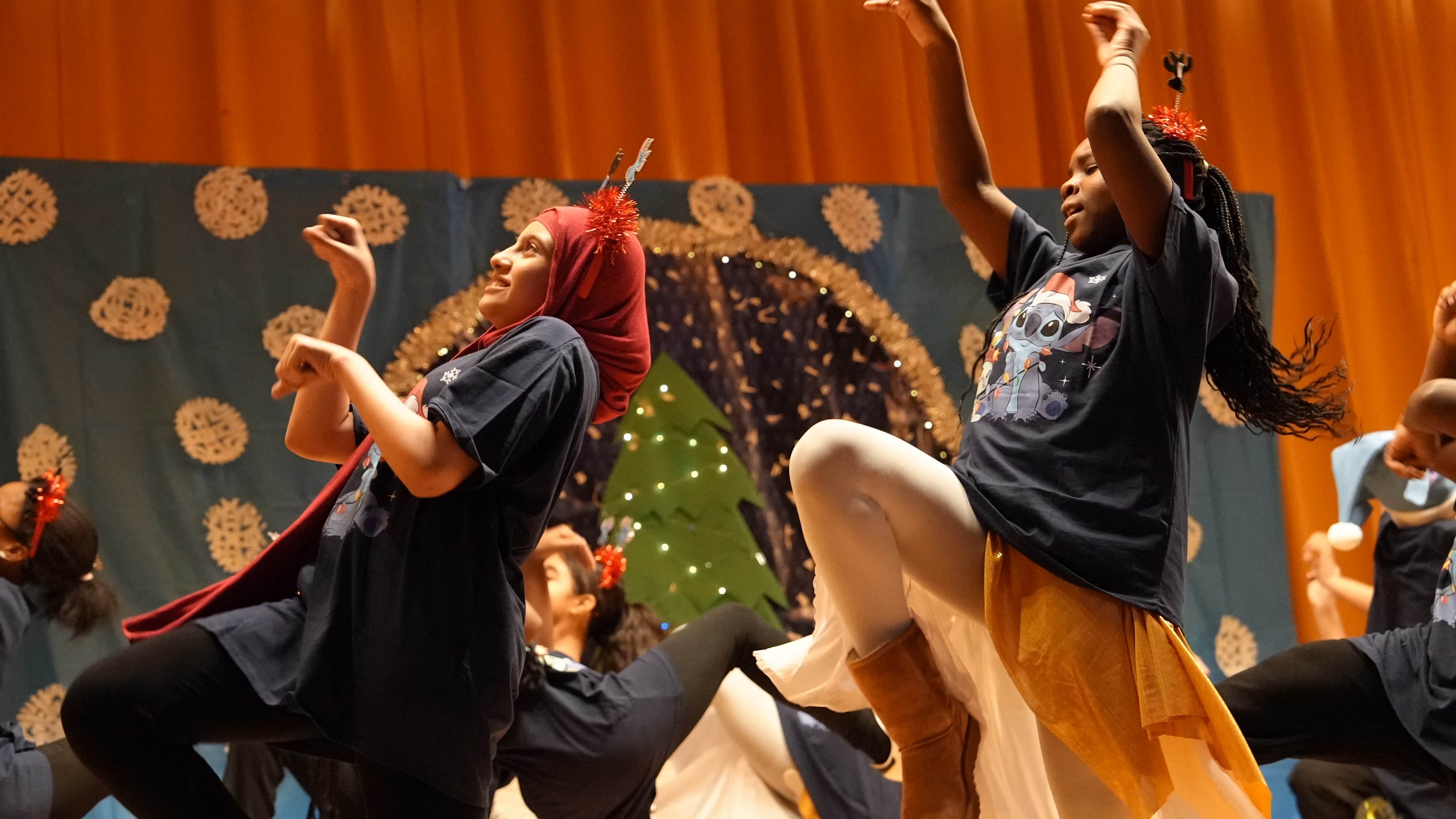 Students performing a holiday dance on stage during school show