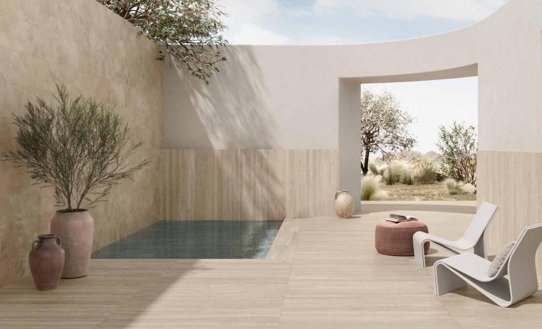 Terrassenbereich mit Pool eingefasst mit Fliesen in Travertinoptik