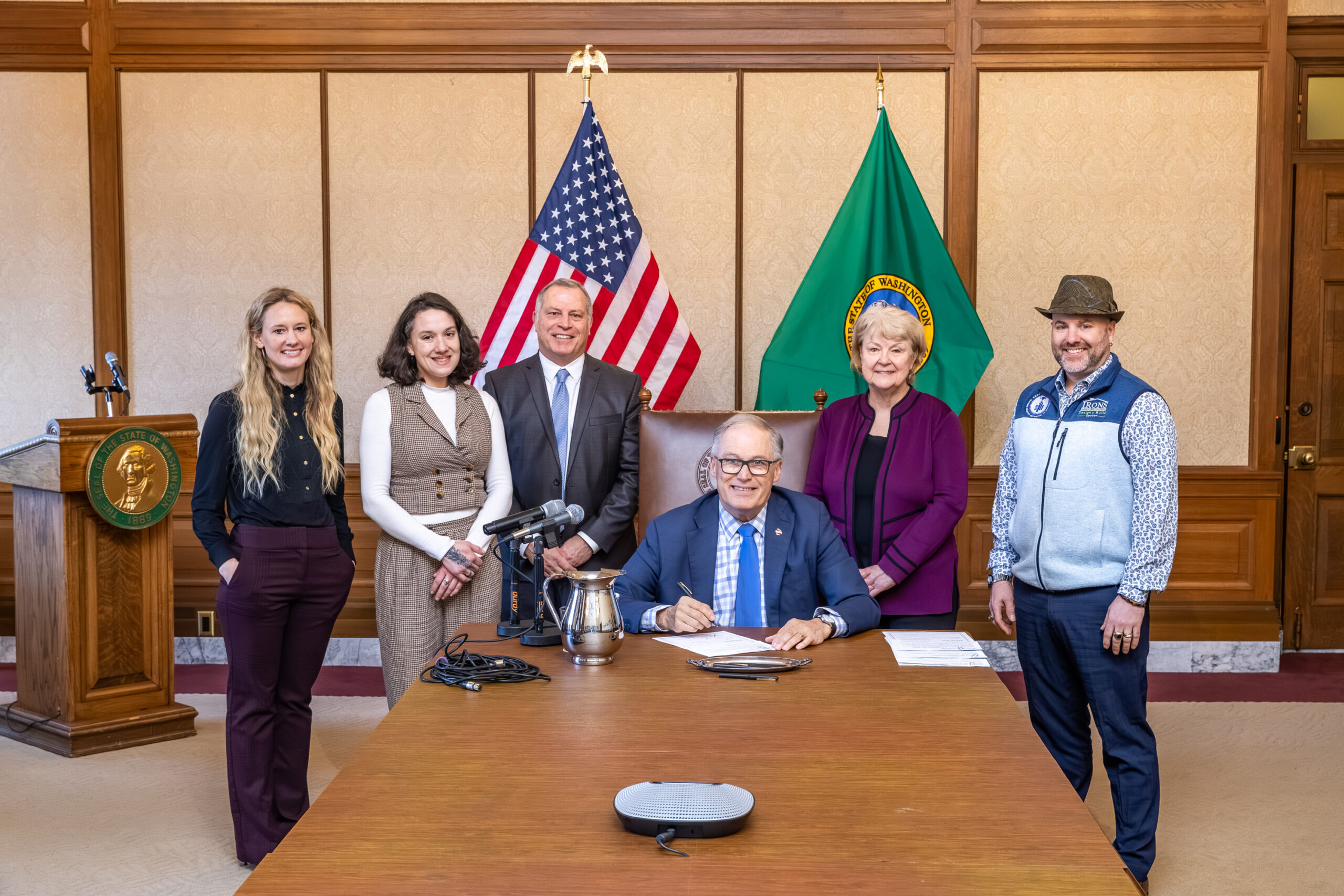 Three women and two men with governor signing bills into law.