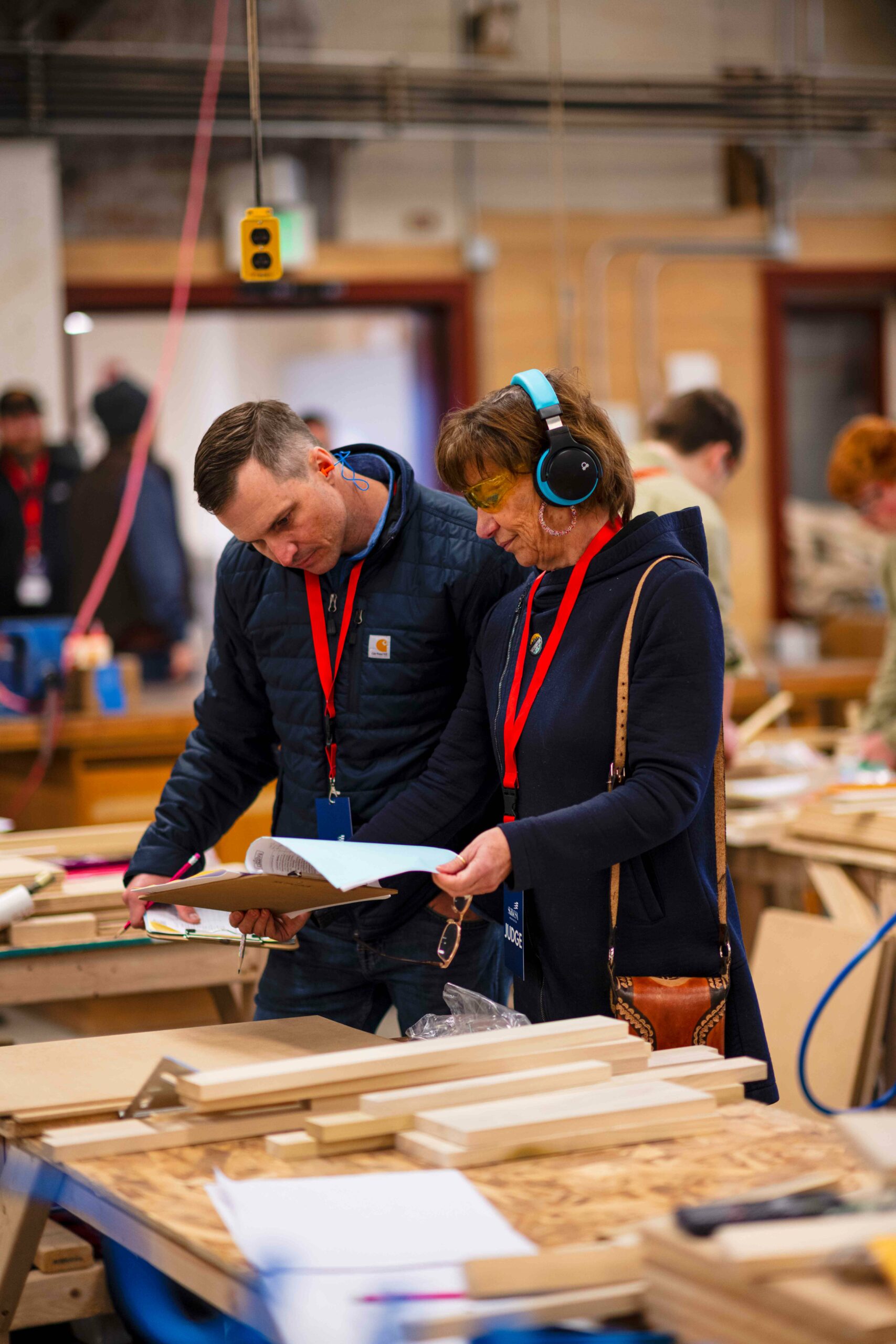 man and woman both in navy jackets review rules for competition in cabinetry