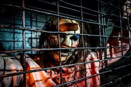 A person in a jail cell wearing a mask.