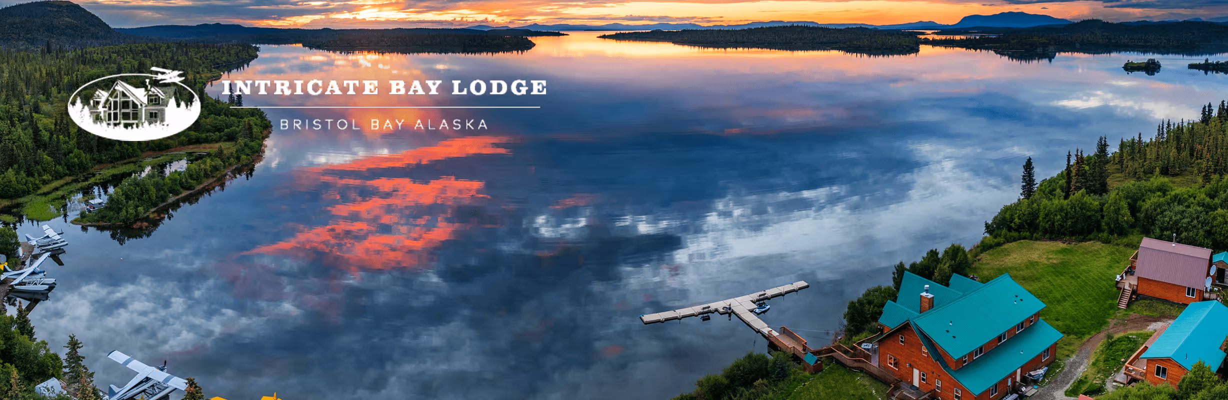 An aerial view of a lake with a plane flying over it.