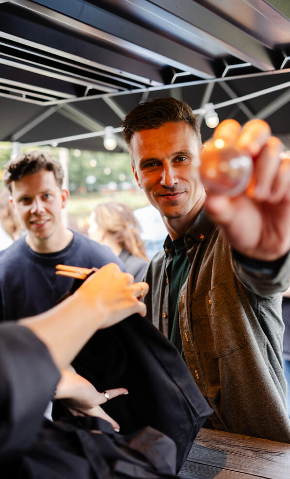 A ZUID. agency team member holding out a small prize ball during a fun outdoor team activity.