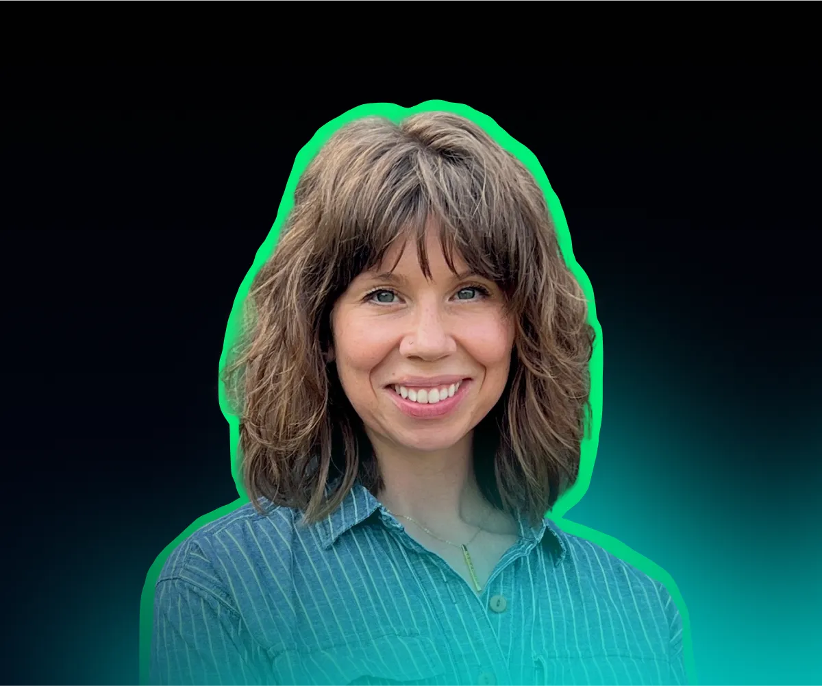 A woman in a green shirt is smiling.