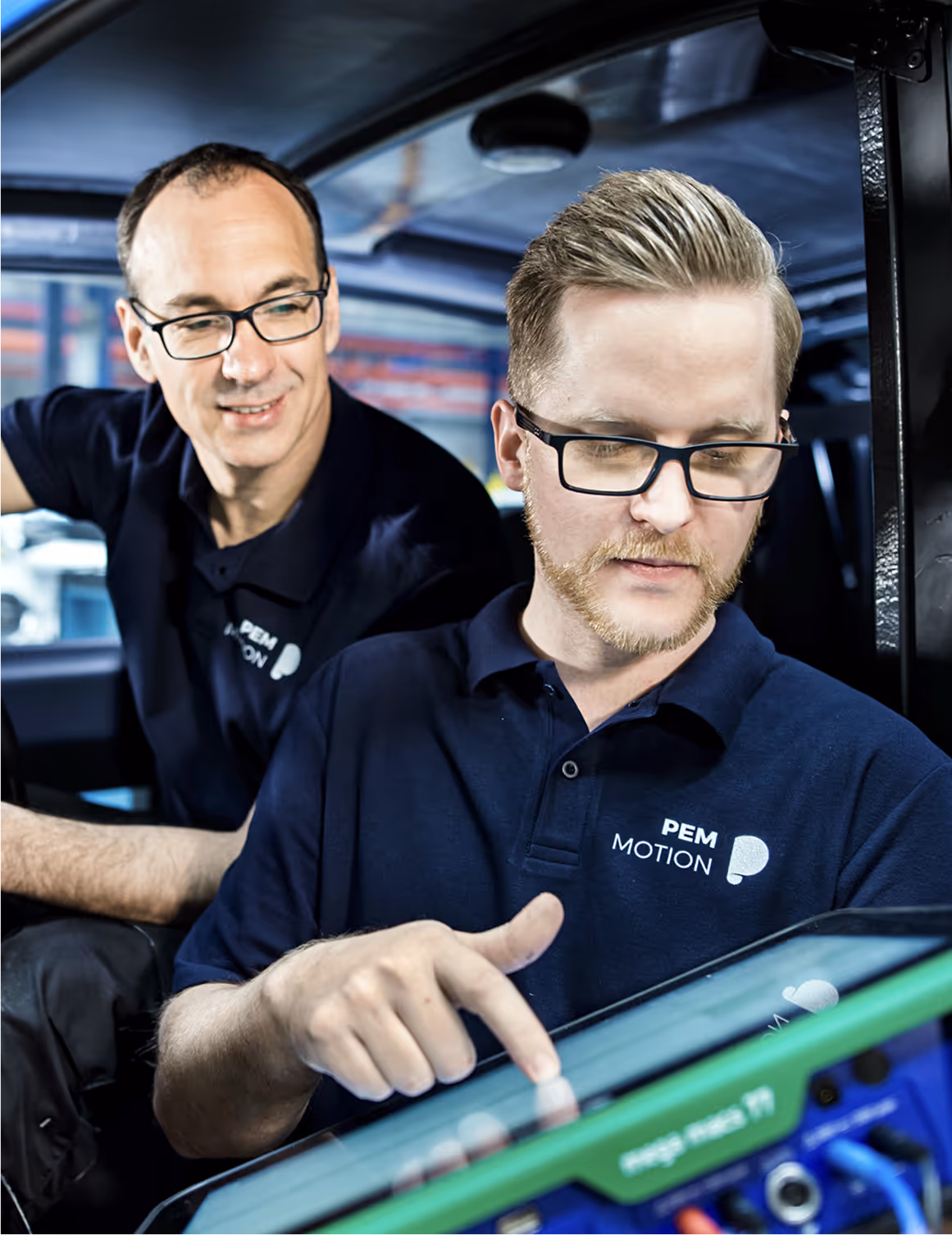 A man in a blue shirt is using a tablet.