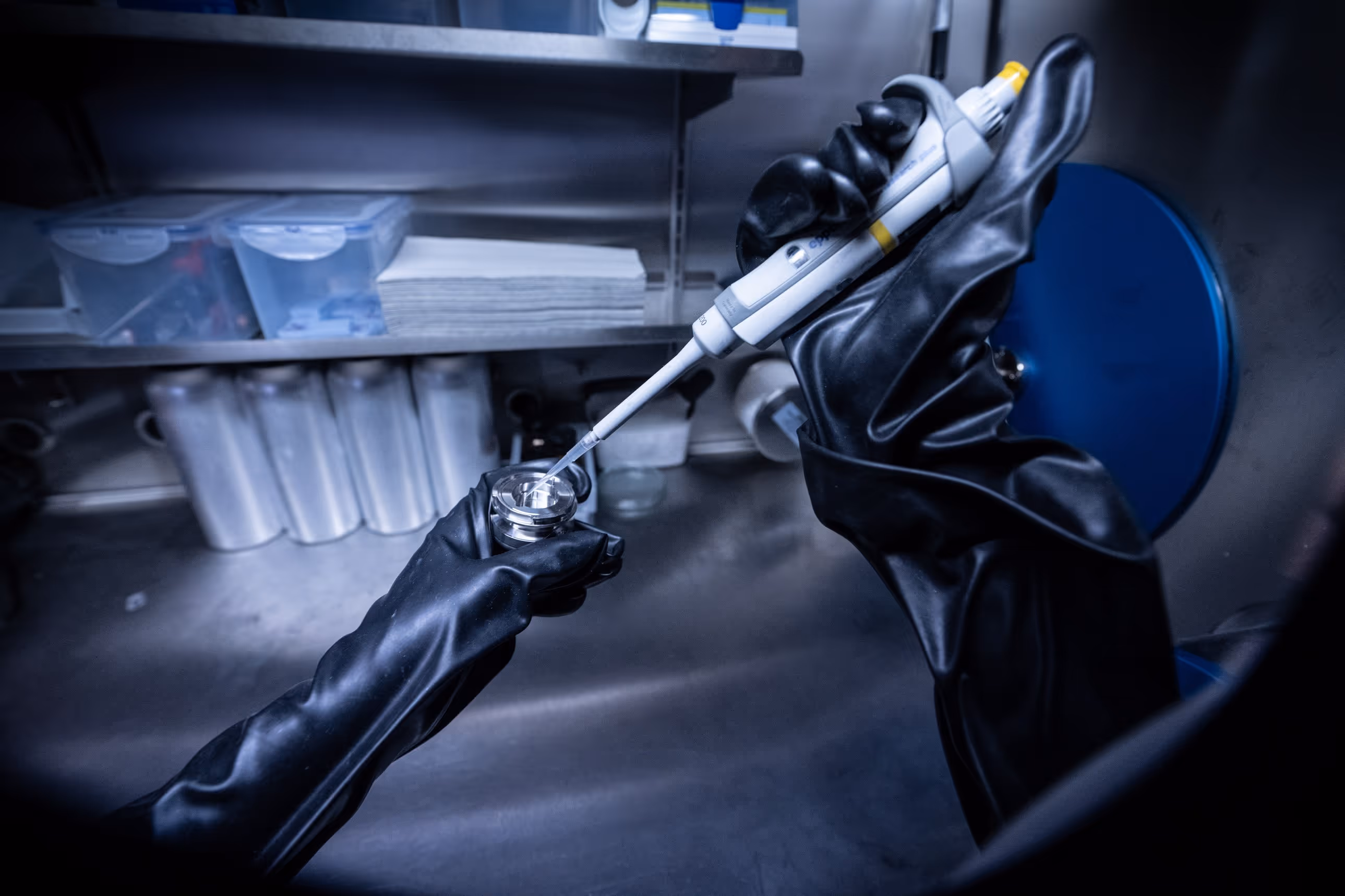 Eine Person mit schwarzen Handschuhen hält ein weißes Rohr.
