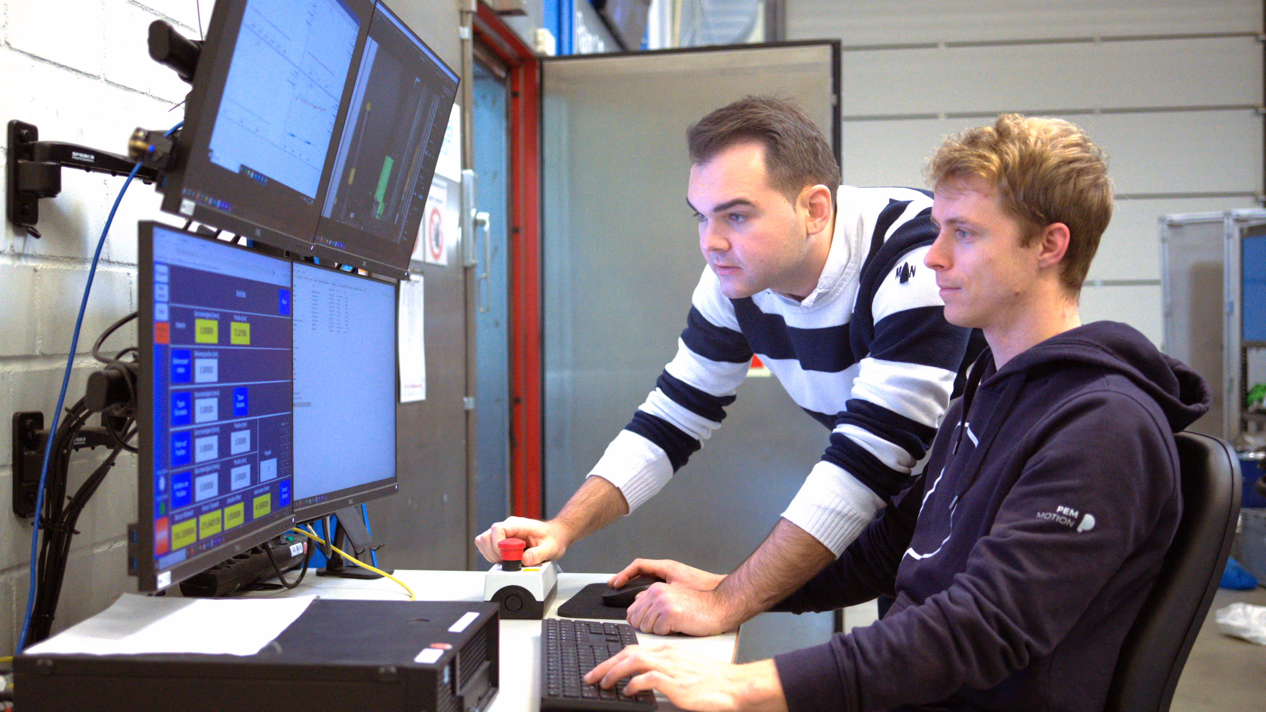 Zwei Männer arbeiten an einem Computer.