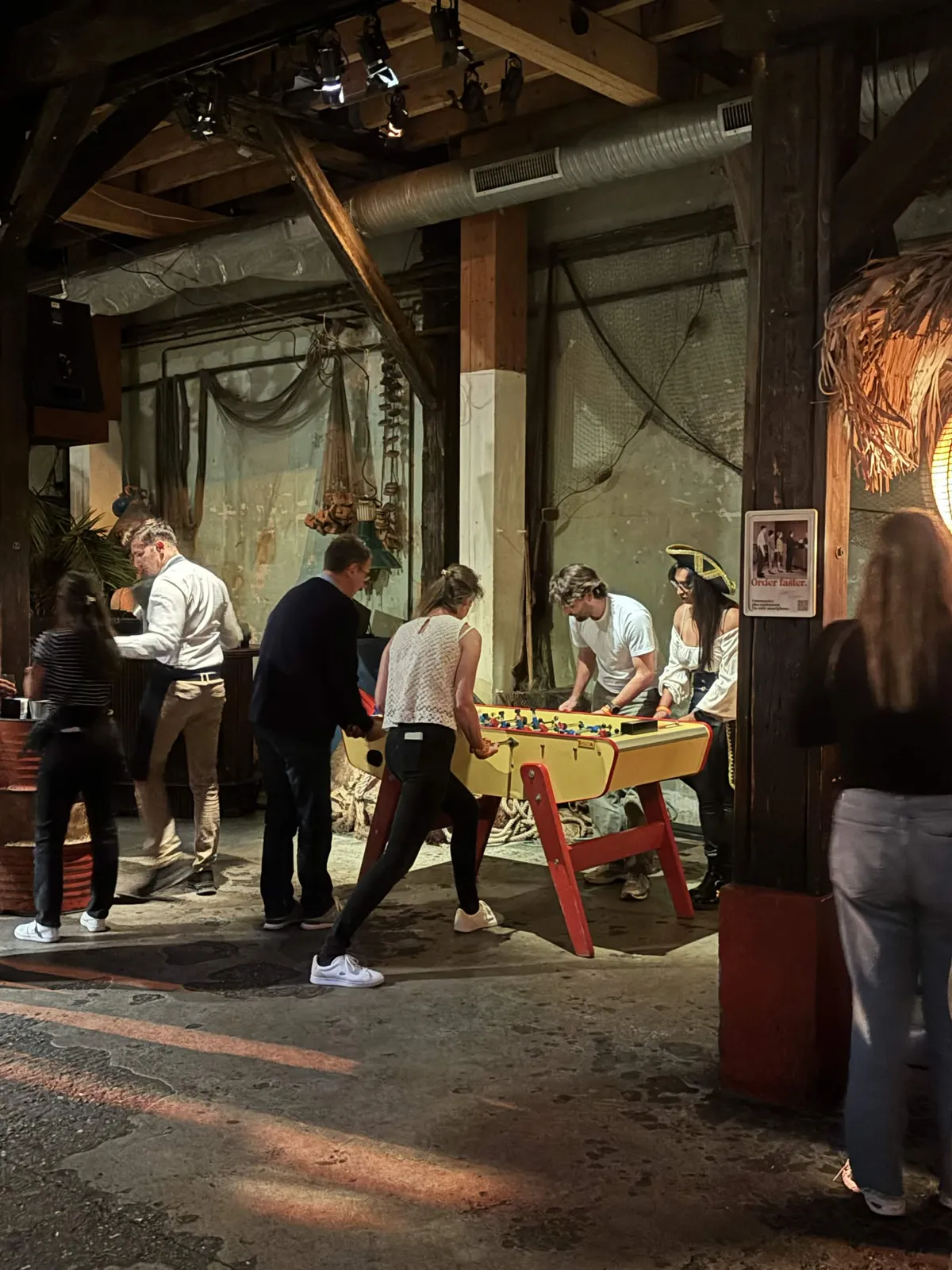 Collaborateurs jouant au baby-foot lors d'une soirée d'entreprise Bistrot