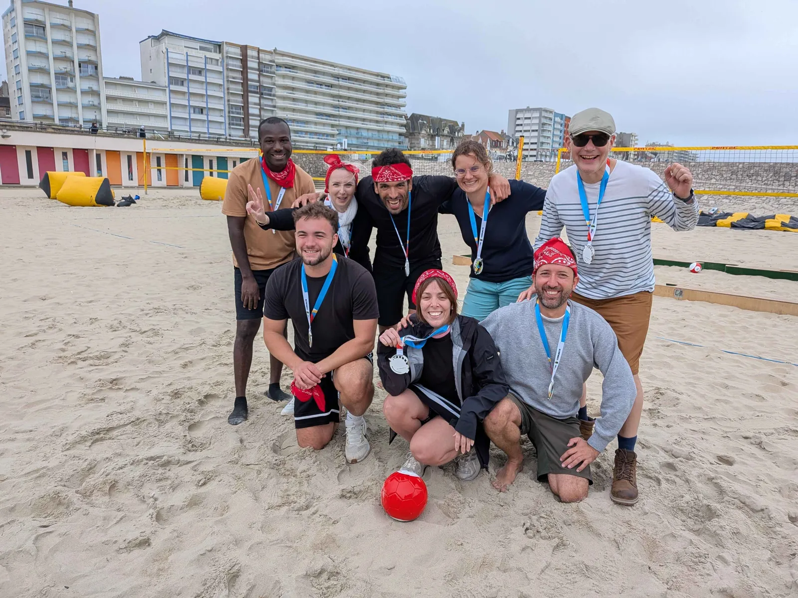 Groupe de collaborateurs réunis sur la plage lors d'un team building Olympiades