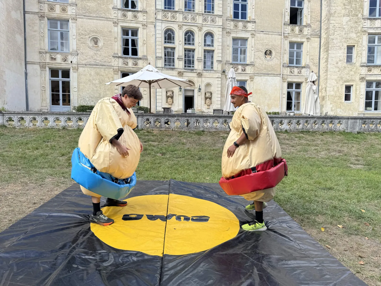 Deux participants en costumes de sumo gonflables lors d'Olympiades de team building