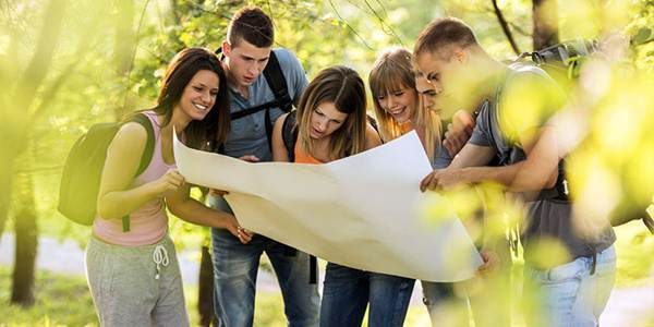 Équipe qui lit une carte d'orientation en forêt pendant une course d'orientation de séminaire