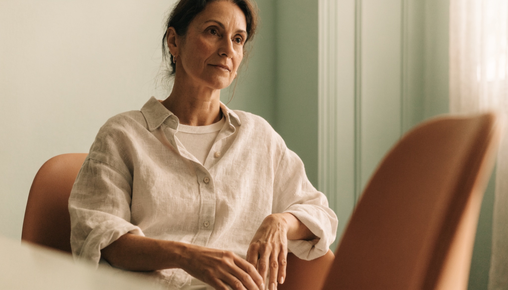 Vrouw in een rustig, geruststellend gesprek in een lichte spreekkamer