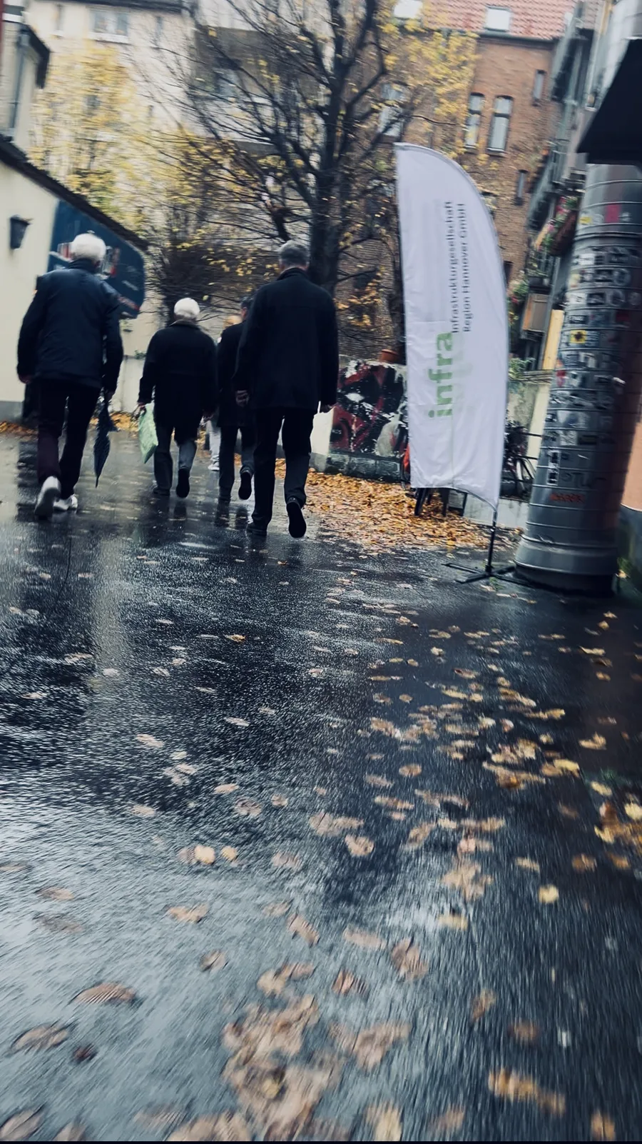 Gäste auf dem Weg ins Apollo Kino, daneben eine Fahne der infra