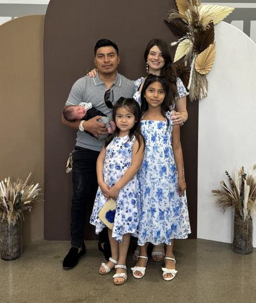 A family photo with Omar and Kylie standing together with their kids at church.