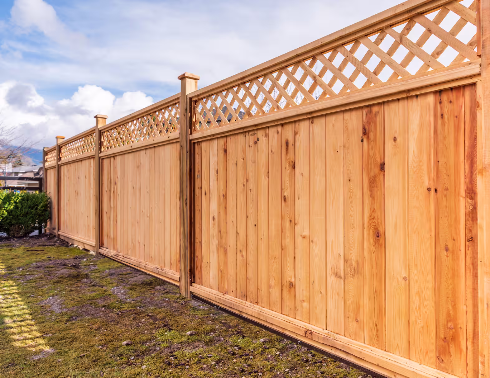 A newly built luxury wooden fence with lattice on the top. 