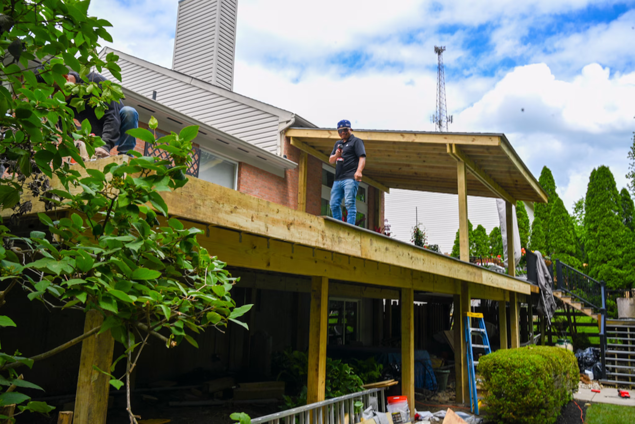 Newly built multi-level wooden structure with workers on top.