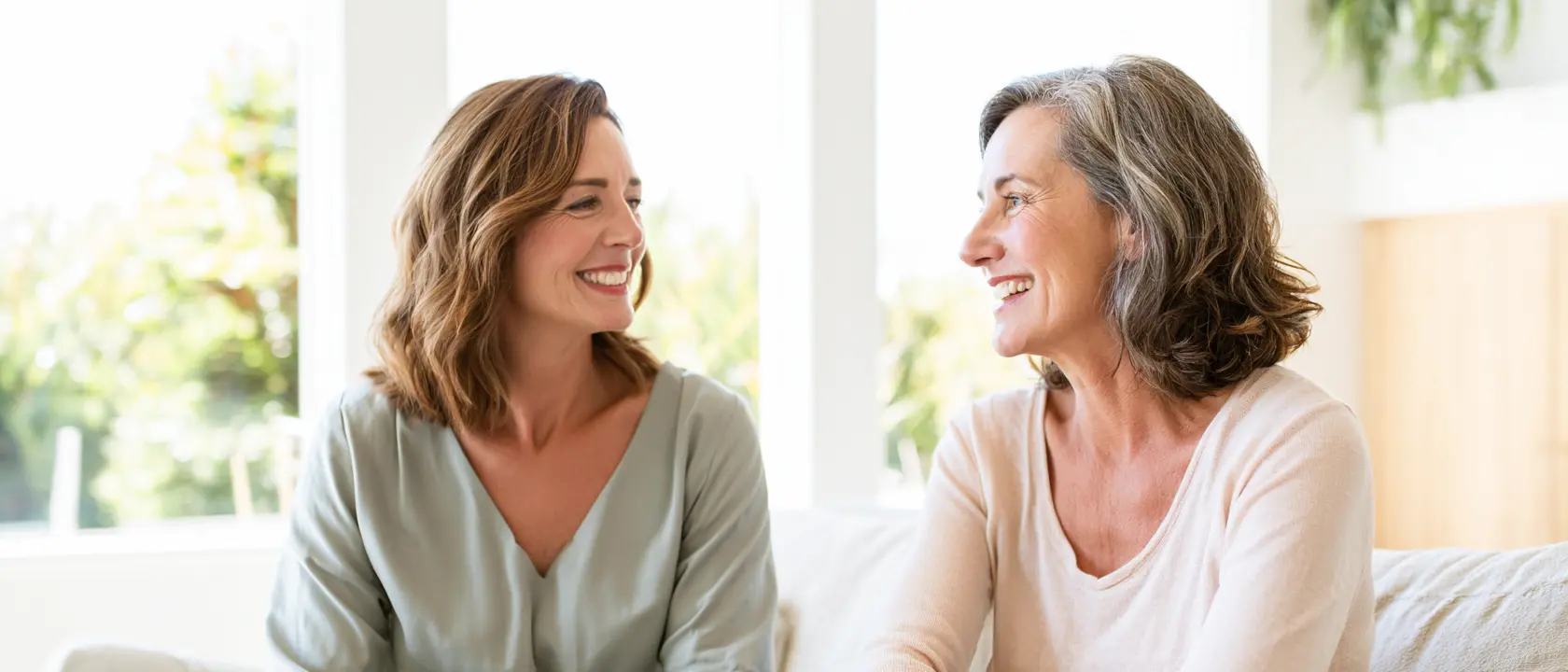 A woman in midlife talking with a functional medicine practitioner in a warm downtown Charleston consultation room.