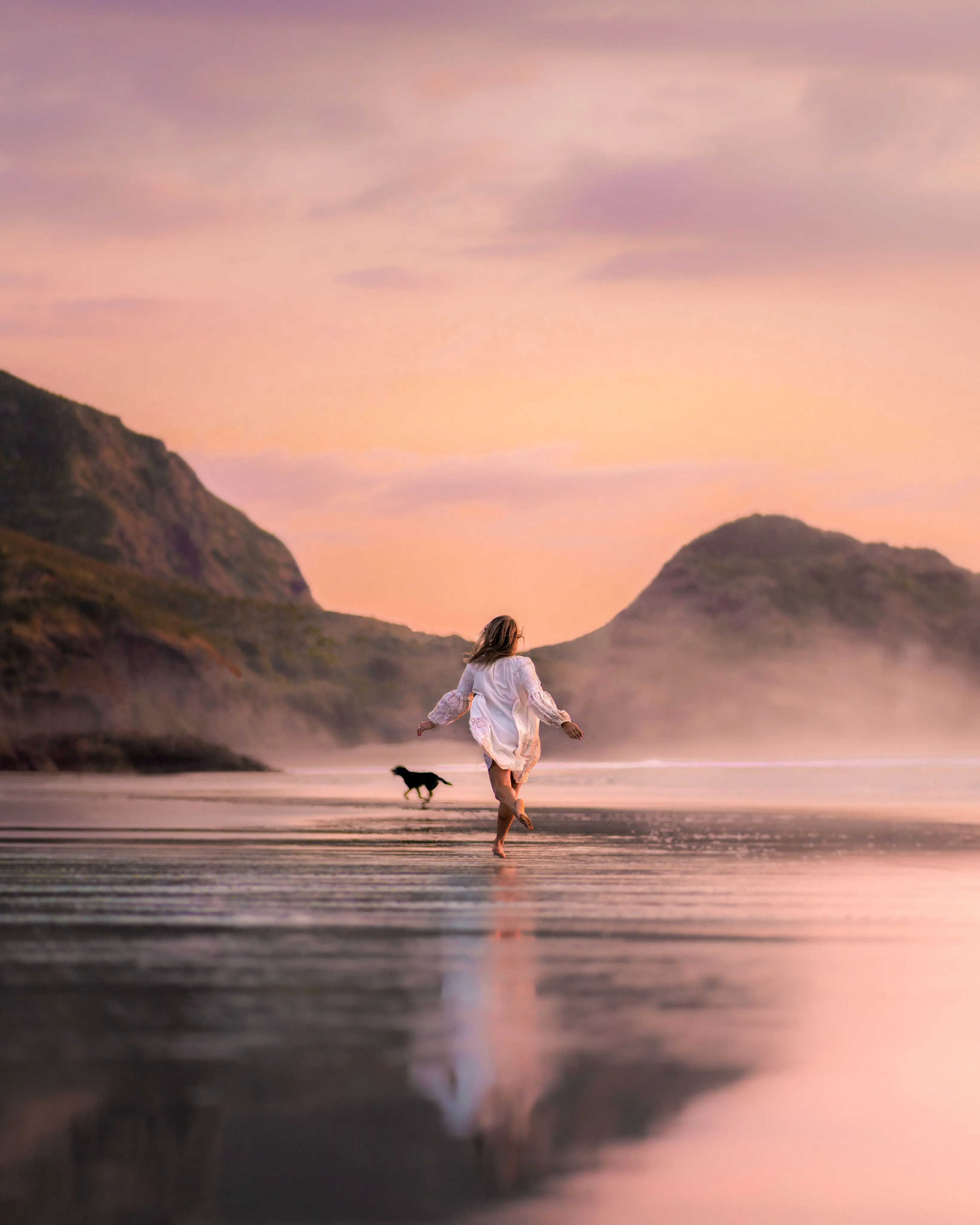 Woman walking a dog along the shore at dusk, anti-aging and functional medicine in Charleston